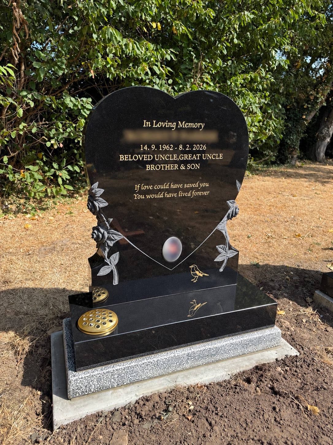 Black granite memorial with carved roses